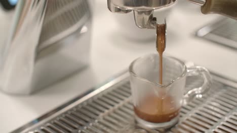 Bernsteinbrauner-Kaffee-Tropft-In-Eine-Glastasse-Auf-Einem-Metallgitter-Im-Weißen-Café