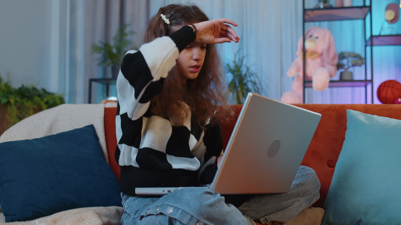 십대 전 소녀는 노트북을 사용합니다. 나쁜 소식, 재산 손실, 실패, 집에서 복권 결과에 놀랐습니다.