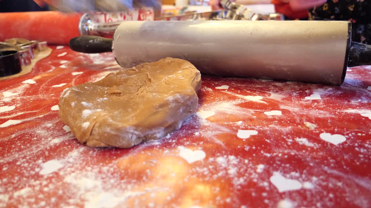 Rolling out gingerbread dough to make holiday cookies for the family - low angle close up