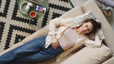 woman lying on sofa and looking at camera