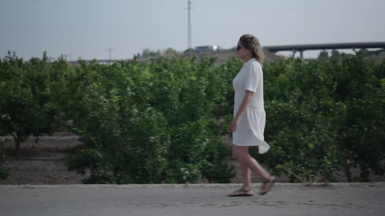 Woman Walking in an Orange Grove