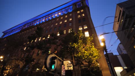 downtown san francisco at night, illumination on buildings and tram power lines, low angle view