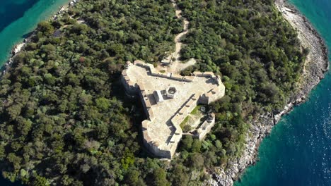 Historic-fortress-of-Medieval-era-in-Albania-built-on-rocky-island-surrounded-by-blue-turquoise-sea