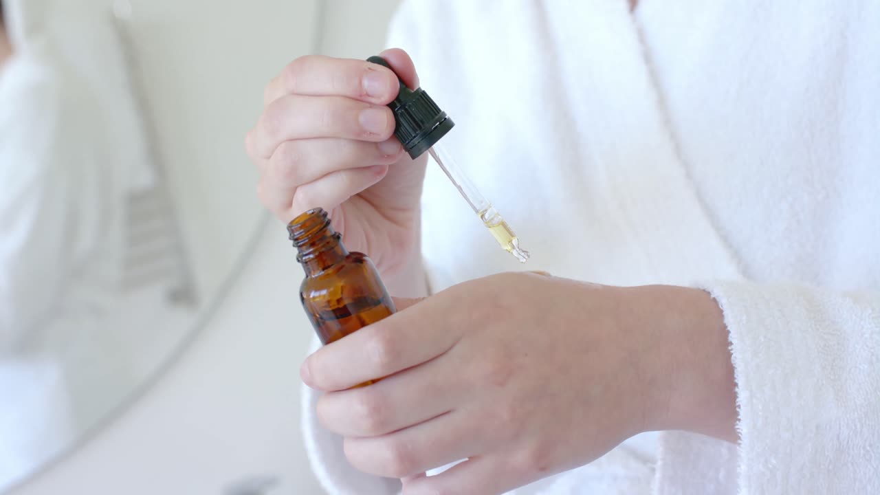 mujer caucásica tomando una muestra de aceite y poniendo la mano en el baño en cámara lenta