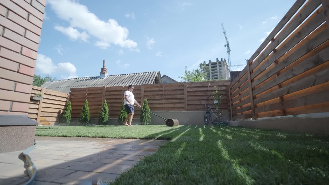 Gardener Laying a Roll of Natural Lawn Turf