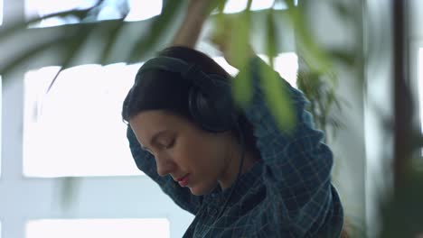 joyful woman enjoying music in headphones at home