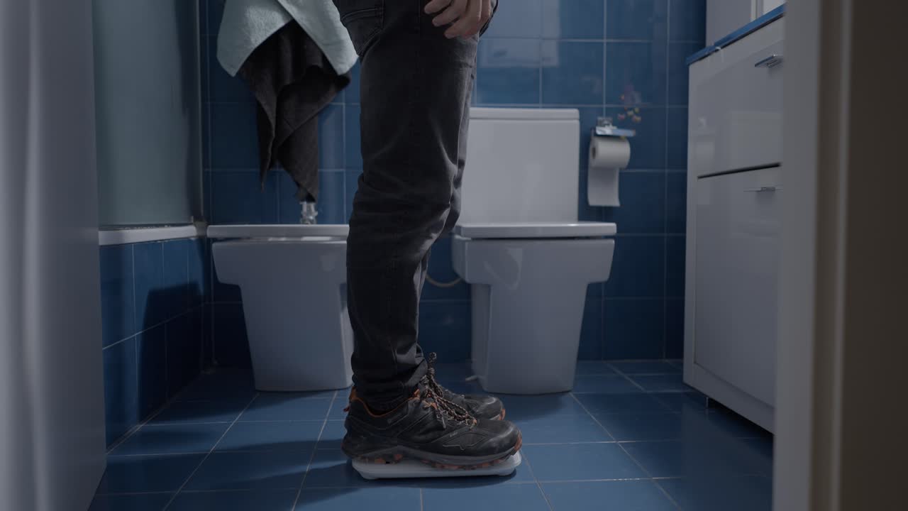 Man Weighing Himself in a Bathroom