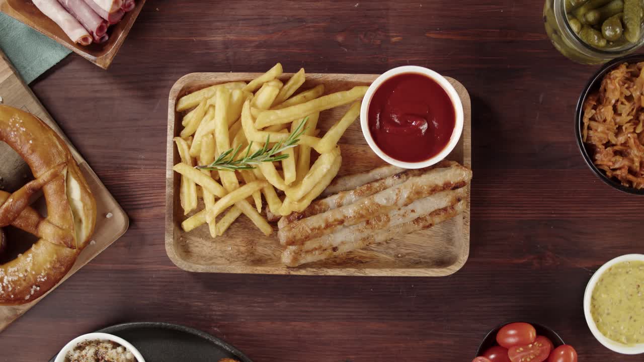Mani che Adagiano Salsicce Tedesche e Patatine Fritte su Tavolo di Legno