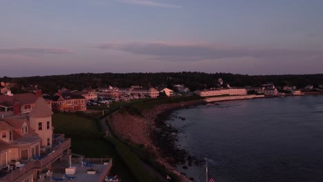 Vista-Aérea-De-La-Costa-Al-Atardecer-De-Ogunquit-Maine-Usa-Drone-Revelando-Un-Complejo-De-Casas-De-Lujo-Frente-Al-Mar