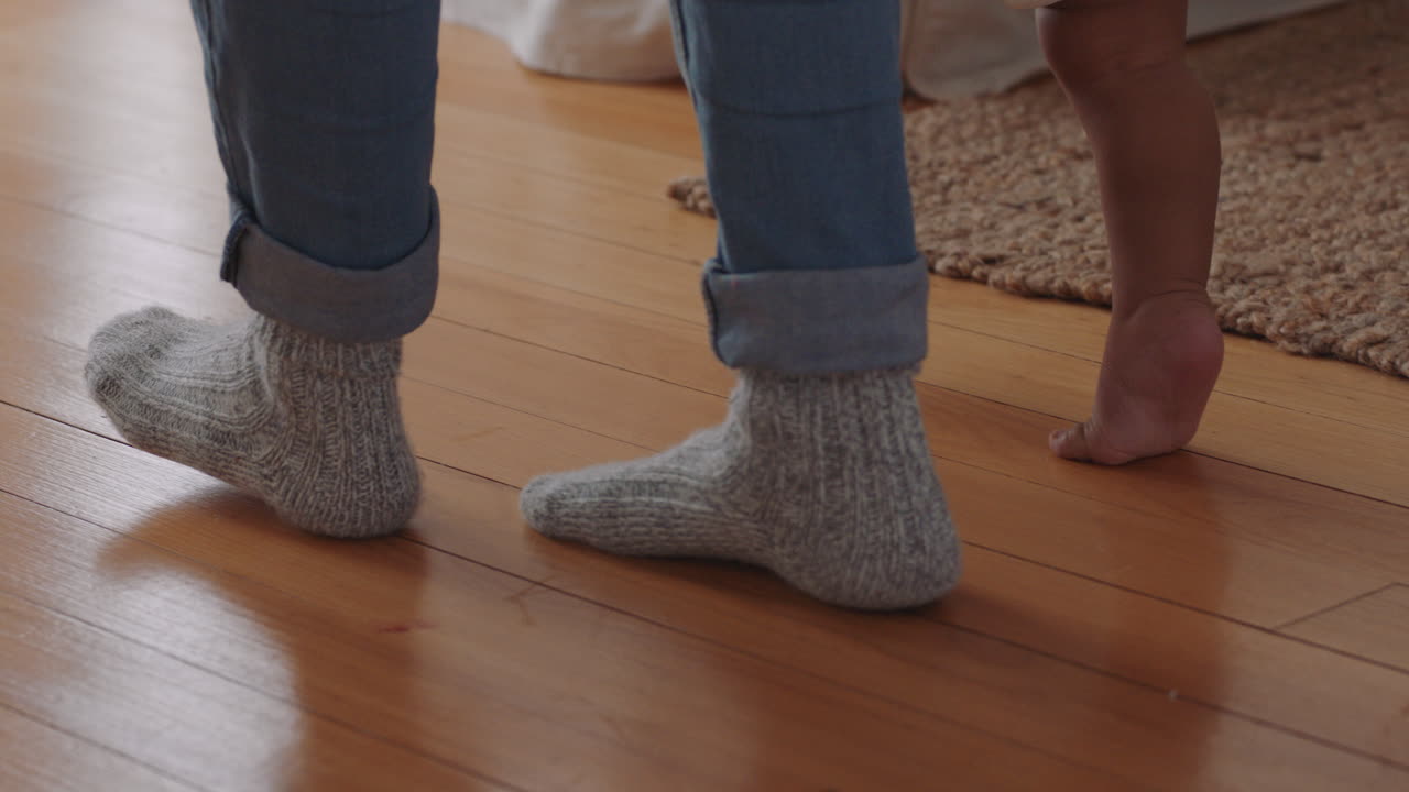 bebé aprendiendo a caminar niño pequeño dando sus primeros pasos con el padre ayudando al bebé enseñando al niño en casa