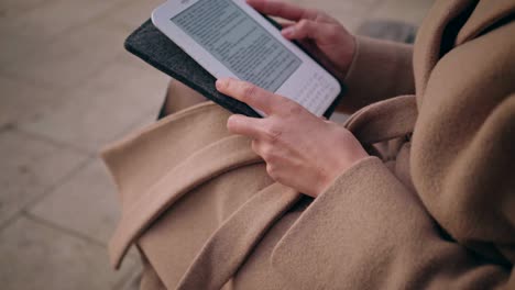 girl with electronic book reader on street