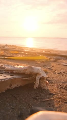 Closeup littered beach shore with pieces of plastic waste thrown out of ocean