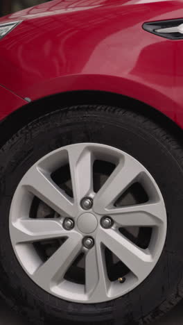 driver stops red car on open parking lot near office building in big city. elegant automobile arrives at destination on sunny summer day closeup