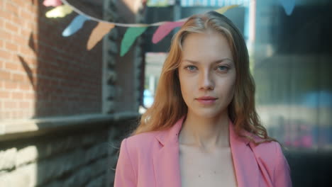 una mujer sonriente con una chaqueta rosa.