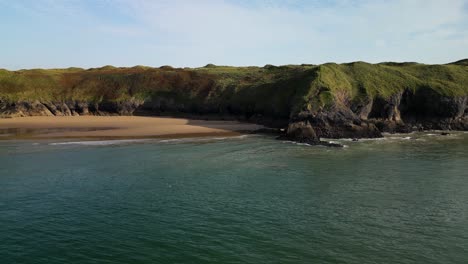 Eine-Luftdrohne-Schoss-über-Das-Meer-Zu-Einem-Strand-Und-über-Einige-Klippen-Auf-Der-Gower-Halbinsel-In-Wales