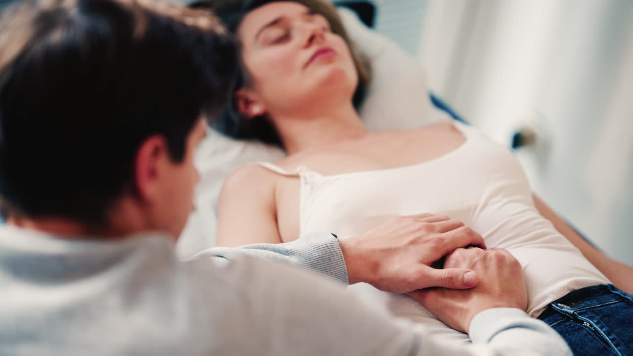Un terapeuta esamina una donna distesa su un lettino medico, posizionando le mani sull'addome come parte di una valutazione o di un trattamento