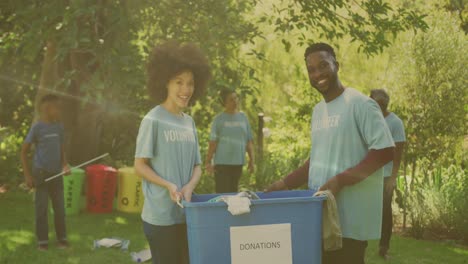 video of lights over happy african american group recycling rubbish in countryside