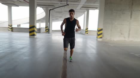 Athlete-runs-inside-the-city-parking-garage,-front-view