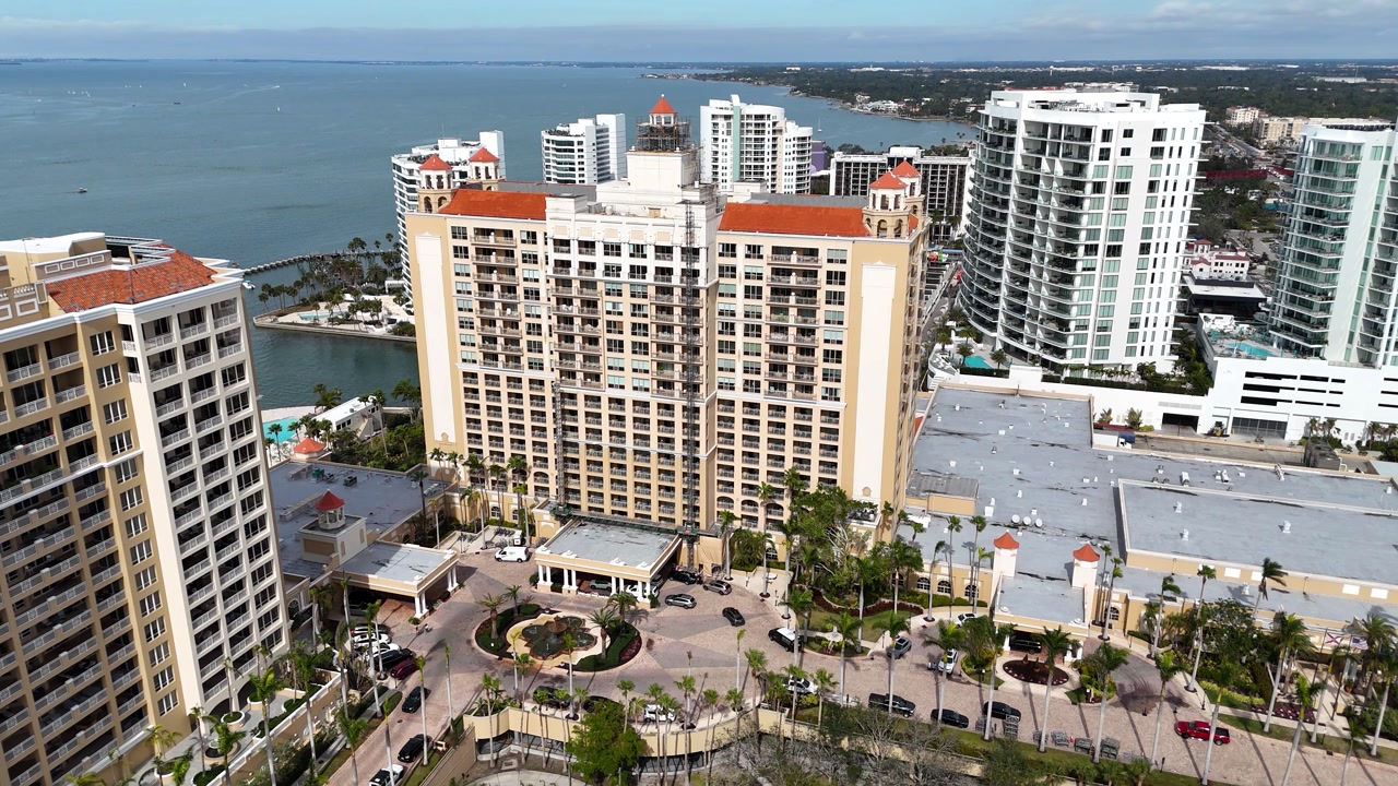 An elevated aerial perspective highlights the luxury hotel’s elegant architecture set against the blue waters of Sarasota Bay.