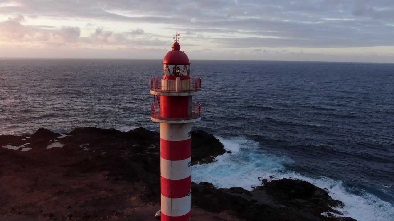 dando vueltas alrededor del hermoso faro de rayas blancas y rojas en las colinas rocosas de gran canaria, españa