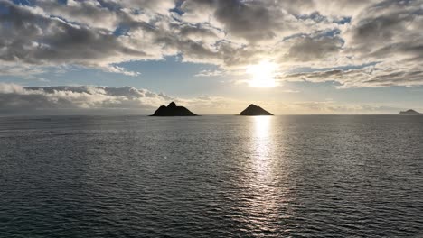 Silhouette-Drohnen-Luftaufnahmen,-Seitliches-Schwenken-Der-Mokulua-Inseln-Bei-Sonnenaufgang-Mit-Klarem,-Offenem-Wasser-Und-Wunderschönen-Morgenwolken