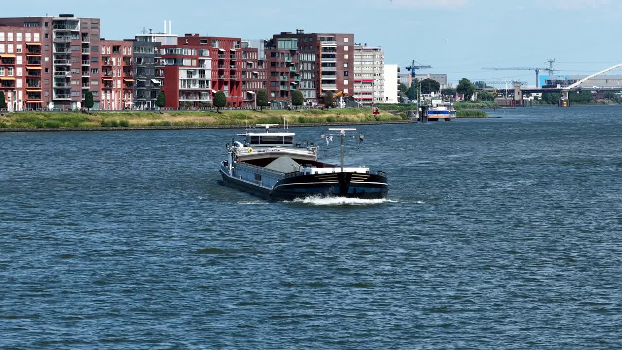 River ferry sails by Dordrecht modern waterfront, calm and serene atmosphere
