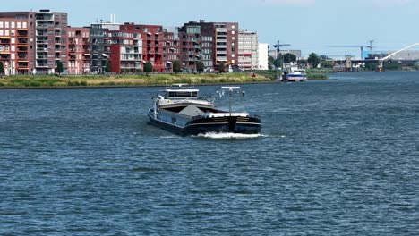 river ferry sails by dordrecht modern waterfront, calm and serene atmosphere
