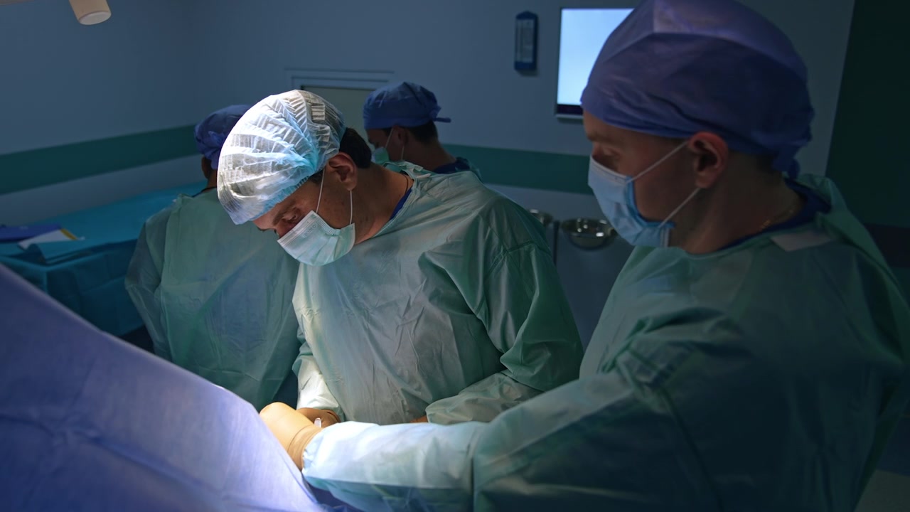 Un medico tiene lo strumento mentre il suo collega usa le pinze. Operazione traumatologica in corso in un ospedale moderno.