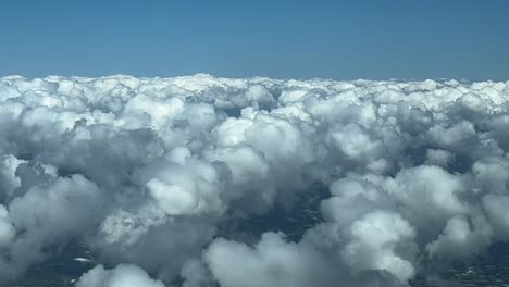 piloto inmersivo pov volando sobre algunas pequeñas nubes de cumulus de algodón y esponjosas en un día soleado y cielo azul, según lo visto por los pilotos