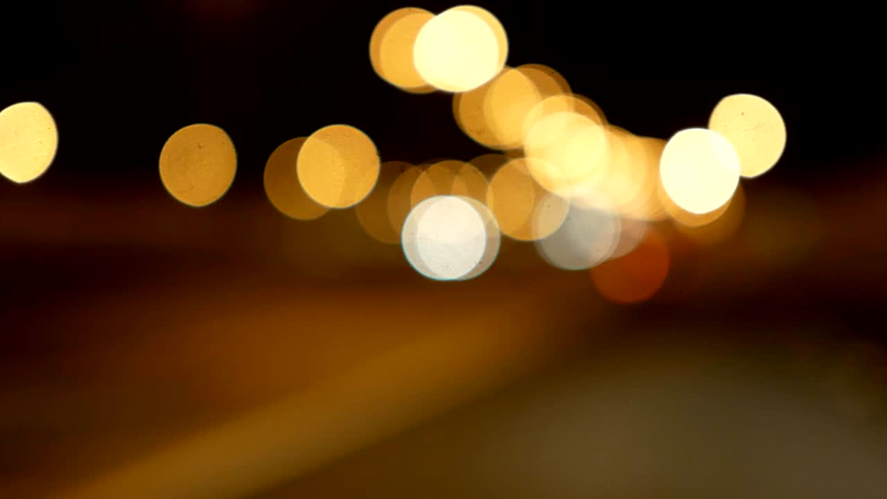 conducir un coche a través de la carretera de la noche, la autopista. luces desenfocadas calle de los ángeles resumen. ciudad fondo borroso. movimientos círculos bokeh de tráfico nocturno.