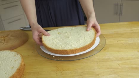 close up of woman hands making sweet cake with white cream and biscuit.