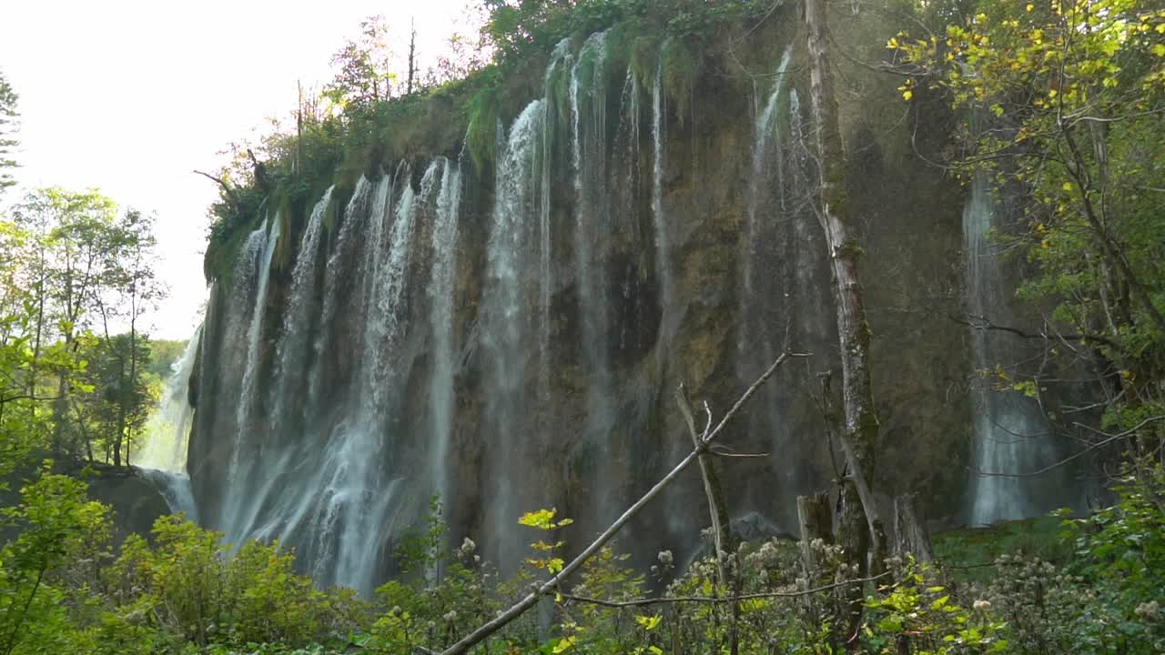 cascadas altas y delgadas con niebla que sopla en el parque nacional de los lagos de plitvice en croacia, europa a ¼ de velocidad