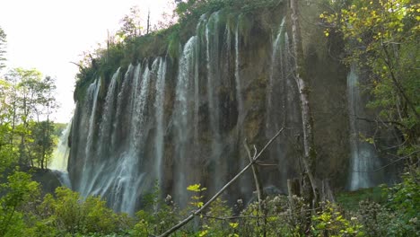 High-thin-waterfalls-with-blowing-mist-at-Plitvice-Lakes-National-Park-in-Croatia,-Europe-at-¼-speed