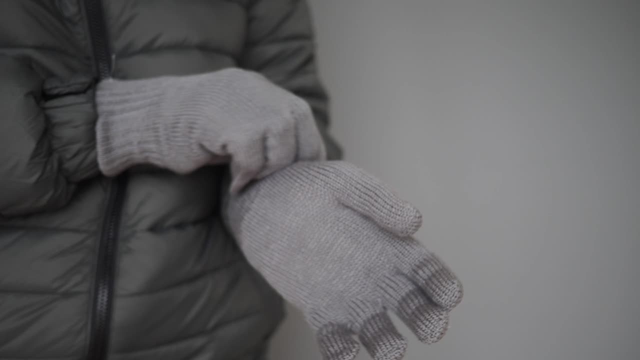 グレーのニット手袋をはめている人のクローズアップ