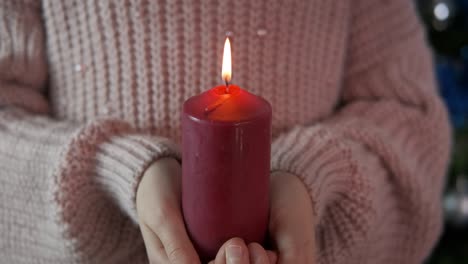 fire of a red candle in hands.