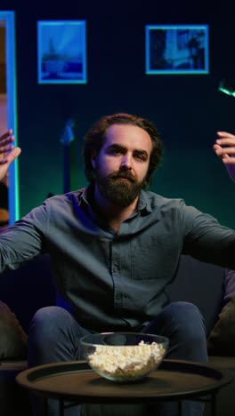 vertical video dejected man at home on couch watching sports match on live broadcast
