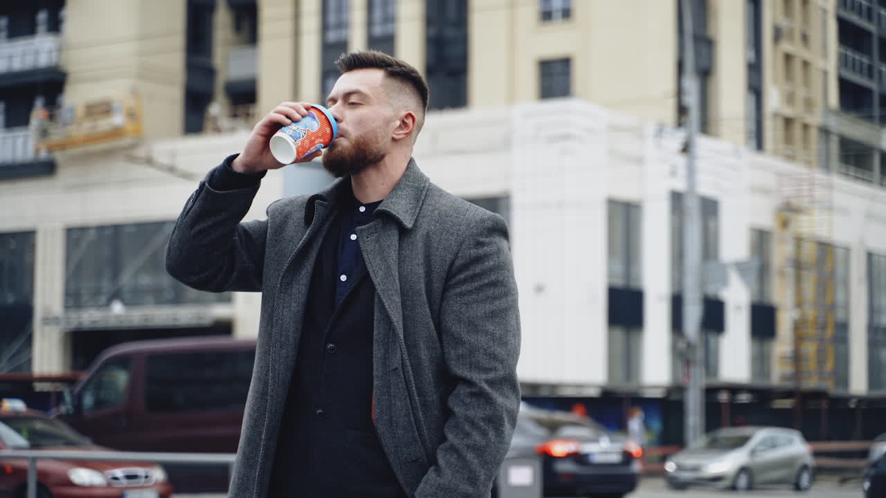 Man with coffee cup outdoor. Young businessman walking through city street and holding takeaway coffee