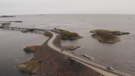 magnificent view of atlantic ocean road in norway with cars crossing the bridge on a cloudy day