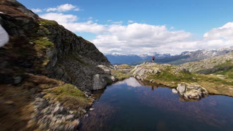 無人機飛過一個風景如畫的冰川水在hardangervidda山高原的頂部, 結束於揭示著名的挪威湖泊和雪山在背景