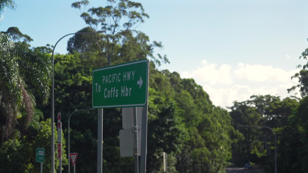 Segnale stradale della Pacific Highway che dirige il traffico verso Coffs Harbour, vicino a The Big Banana, ripresa a mano libera, Coffs Harbour, Nuovo Galles del Sud, Australia.