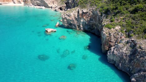 Aerial-drone-views-over-a-rocky-coastline,-turquoise-sea