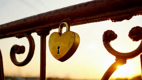 heart-shaped love lock on a sunset bridge