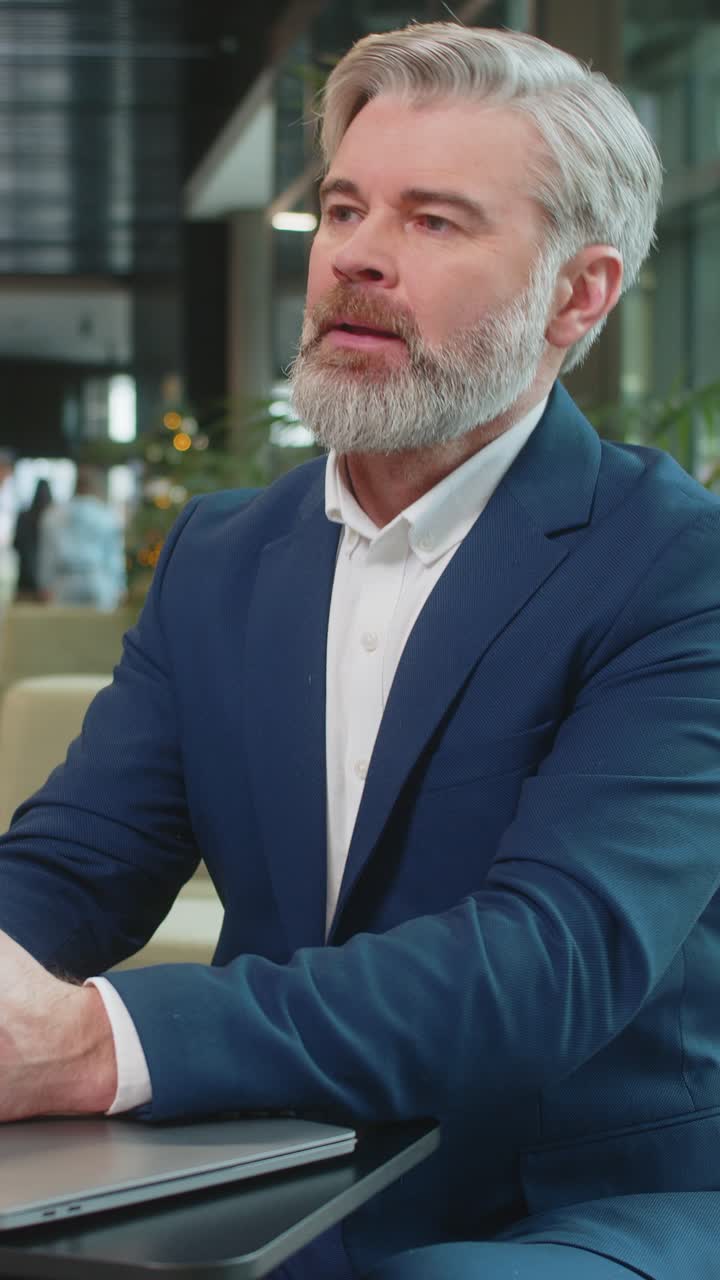 Sad businessman using laptop loses becoming shocked sudden lottery results in modern hotel lobby