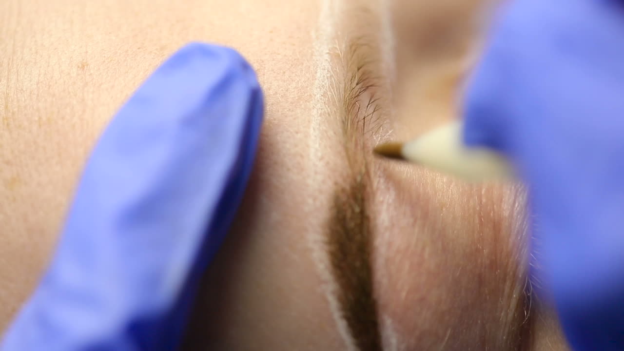 Attractive lady getting facial care and eyebrow tattoo