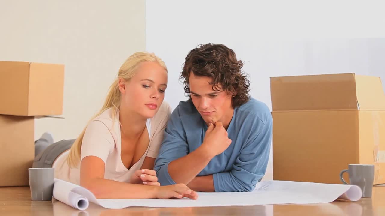 부부 는 새 거실 을 어떻게 꾸미는지 계획 하고 있다