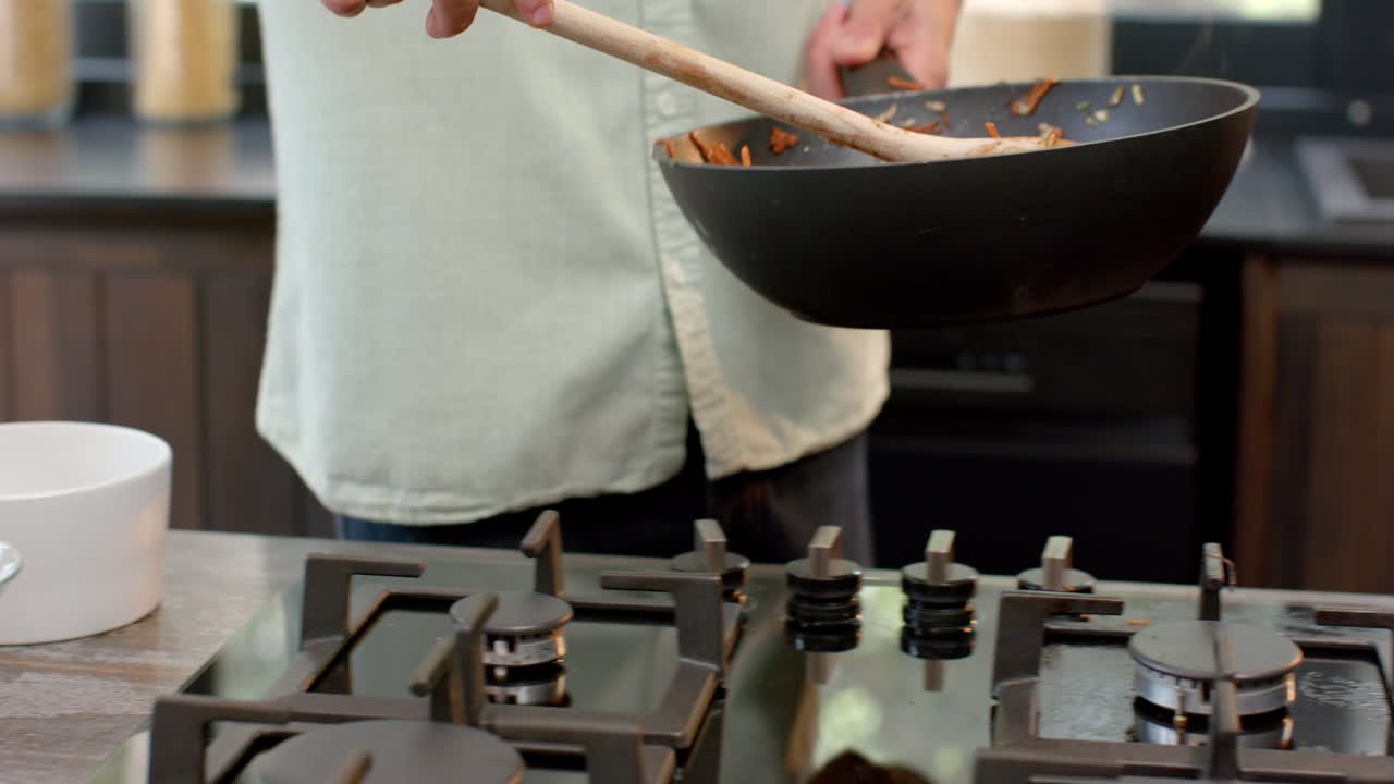Cooking stir-fry in kitchen, Asian man preparing festive holiday meal