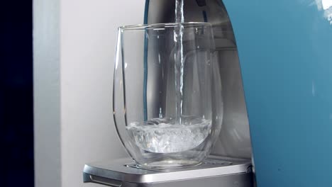 close up slow motion of a water cup filling in a water filtering machine