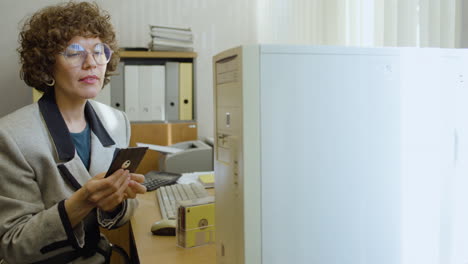 una mujer de negocios usando una computadora sentada en un escritorio.