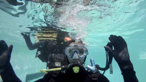 People-in-scuba-gear-looking-at-camera-