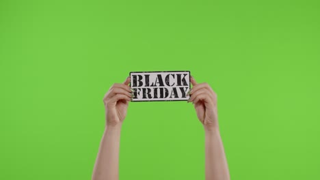 Black-Friday-advertisement-inscription-on-paper-sheet-in-womans-hands-on-chroma-key.-Slow-motion